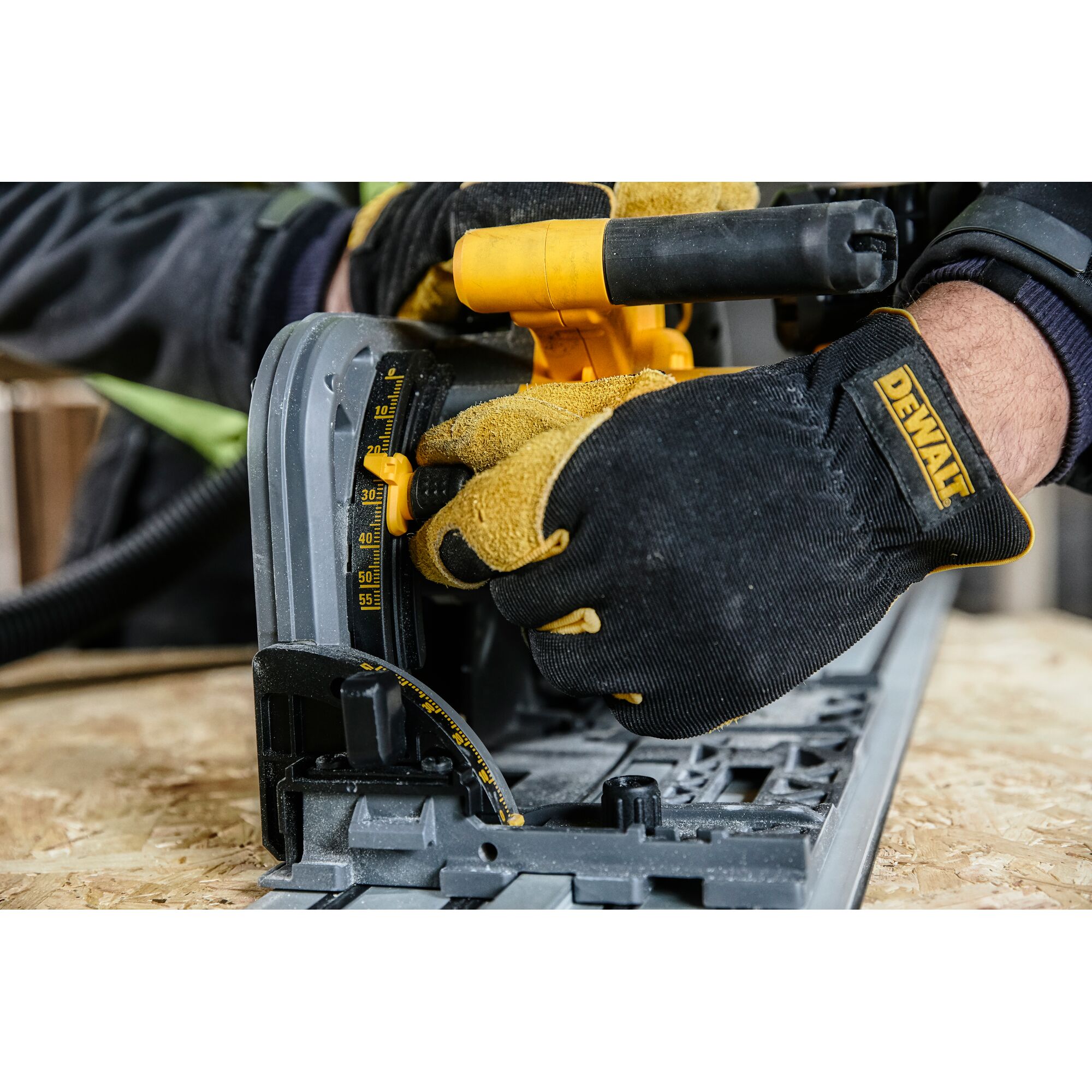 Gloved hands adjust a DEWALT circular saw angle on plywood. Close-up of tool and measurement gauge.