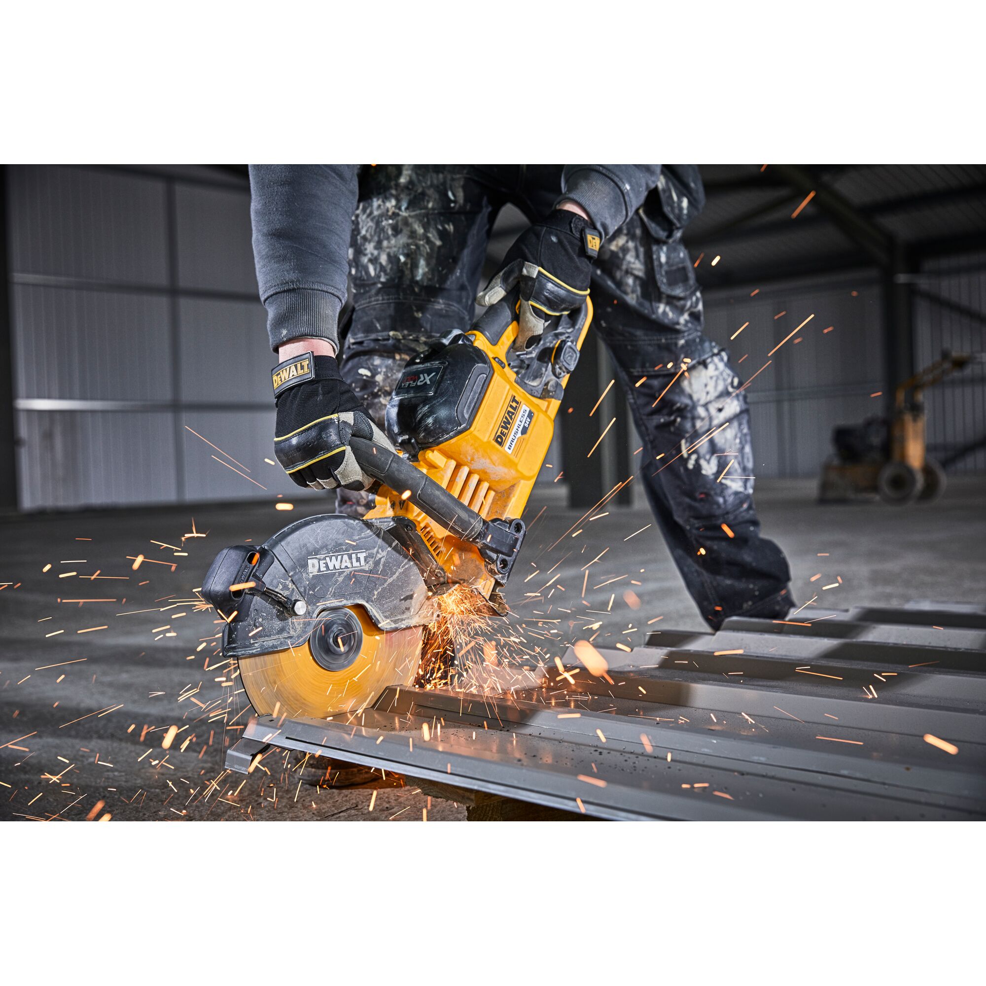 Person uses DEWALT DCS690N saw to cut metal, creating sparks in an industrial setting.