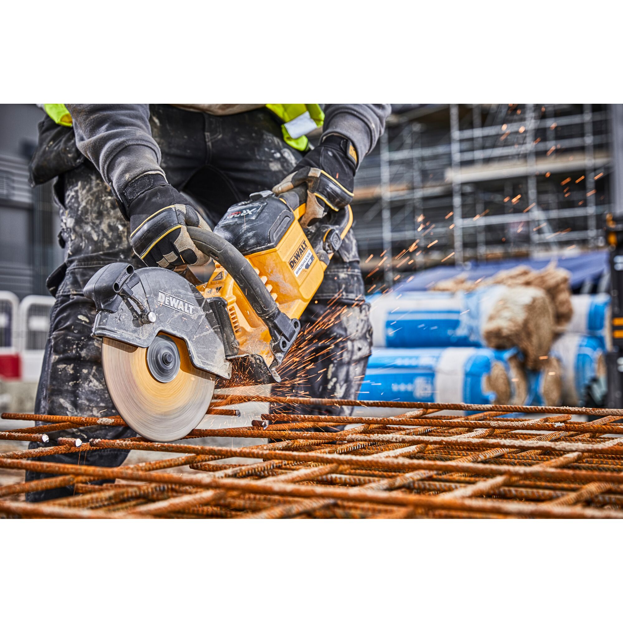 Worker uses DEWALT DCS690N saw to cut metal rods, sparks flying, at a construction site.