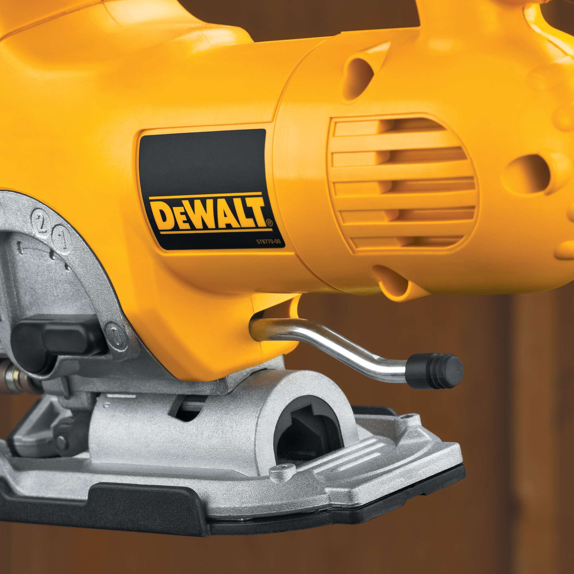 Close-up of a DEWALT electric jigsaw in yellow and silver, showing the brand logo and part of the metal base.